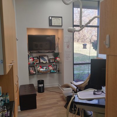 operatory with chair, a TV, shelving with pictures